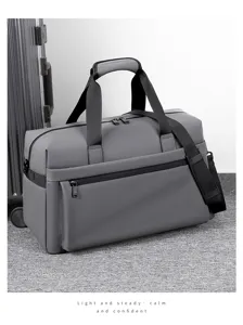 Vista dettagliata della borsa da viaggio grigia, con tessuto resistente e manici robusti.