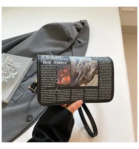 Newspaper print small shoulder crossbody bag with wrist strap, trendy fashion accessory.