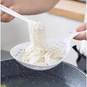 White plastic kitchen slotted spoon with long handle for draining noodles and dumplings easily.