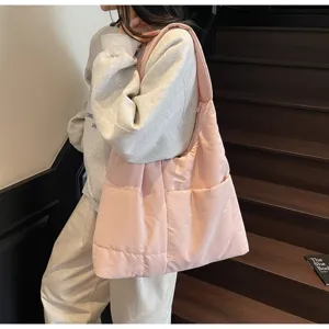 Detailed view of the pink quilted shoulder bag showing soft puffer texture and side pocket.