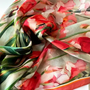 Close-up detail of smooth mulberry silk scarf with vibrant floral watercolor print pattern.