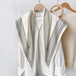 Retro black and white paisley bandana scarf paired with a classic white blouse detail view.