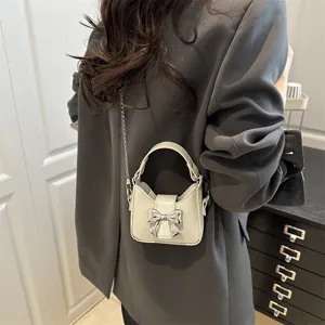 Korean style mini bow handbag for girls, cute white PU leather crossbody shoulder bag with chain.