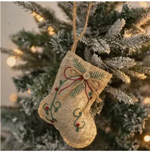 Detailed view of rustic burlap Christmas stocking ornament with embroidered pine needles