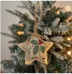 Detail of star-shaped burlap Christmas ornament featuring holly leaf print and twine loop