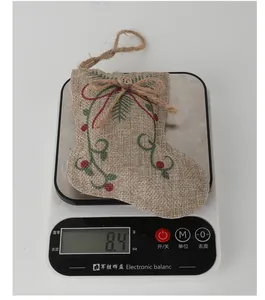 Burlap Christmas stocking ornament weight measurement showing 8.4 grams on digital scale