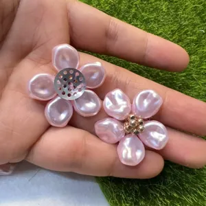 Nahaufnahme der rosa DIY Perlenblumen Accessoires mit Metallnetz und goldenen Perlen.