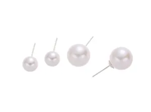 Primo piano dettagliato di orecchini a lobo con perle bianche e perni in argento fine.