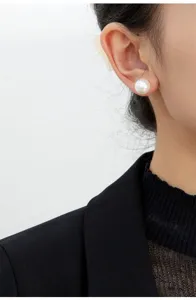 Vista dettagliata di un orecchino di perla minimalista indossato, design elegante e senza tempo.