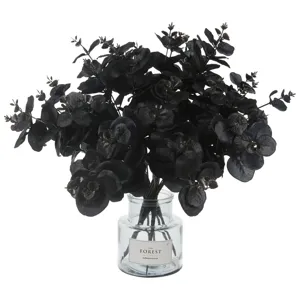 Black artificial eucalyptus leaves in glass vase, fake plant for home decor and party.