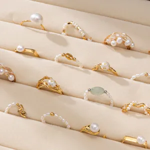 Détail de bagues assorties en perles d'eau douce en boîte velours, bijoux dorés vintage.
