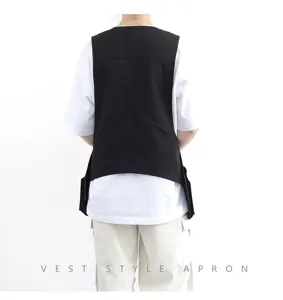 Tablier de style gilet noir avec poches, vêtement de travail professionnel pour cuisinier.
