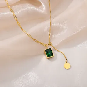 Detailed view of the elegant gold pendant necklace featuring a green gemstone and chic chain.