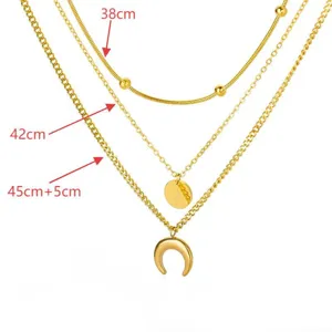 Multi-layer gold tone chain necklace featuring moon and coin pendants with adjustable length.