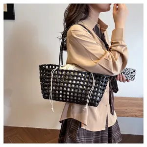 Detailed shot of a black PVC woven tote bag, chic shoulder bag for daily casual style.