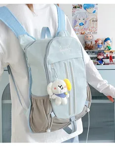 Detail shot of the light blue college backpack worn by model, featuring cute plush pendant.