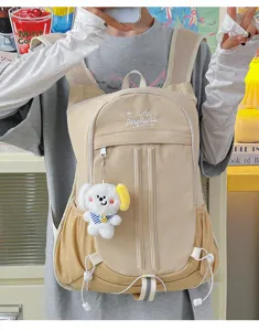 Detail view of the casual canvas school backpack with cute puppy pendant and mesh side pockets.