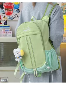 Detail view of the cute college style green backpack featuring a soft plush dog pendant and mesh.