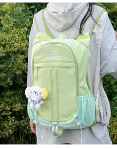 Detailed view of the cute light green college style backpack with cute plush pendant.