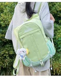 Detail view of the cute light green college style student backpack outdoors with a sweet pendant.