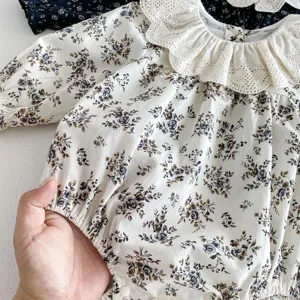 Detailansicht des langärmeligen Baby Mädchen Blumenstramplers mit feinem Spitzenkragen.