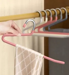 Detail view of S-shaped non-slip stainless steel pants hanger in wardrobe scene setup.