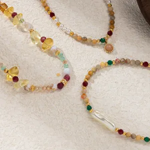 Close-up detail view of luxury natural stone and pearl beaded necklace set with gold accents.