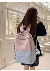 Detail shot of student backpack worn by model, highlighting large capacity and dual color.