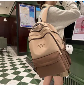 Detail shot of the two-tone canvas backpack worn by model, showcasing multi-pocket and straps.