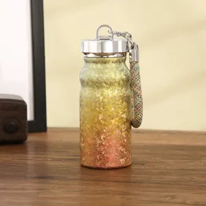 Dettaglio della mini borraccia termica portatile con cordino intrecciato e design dorato sfumato.