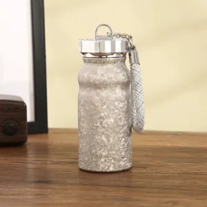 Vista dettagliata della mini borraccia termica portatile con texture glitterata e cordino.