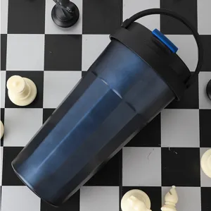 Stainless steel insulated coffee tumbler detail shot with portable handle and chess background.