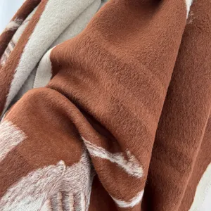 Detalle de una bufanda gruesa de cachemira sintética con patrón jacquard de caballo