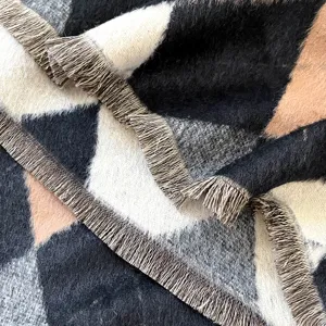 Détail macro d'une écharpe en faux cachemire avec texture jacquard et bords à franges