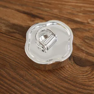 Dettaglio del coperchio della tazza termica portatile in metallo argentato lucido.