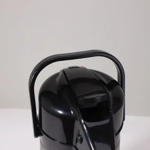 Close-up detail of black thermal airpot handle and pump lid, simple home water kettle design.