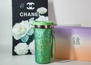 Vue détaillée de la tasse en titane pur pailleté vert luxueux avec sangle pour voyage.