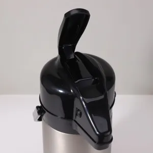 Stainless steel thermal airpot pump lid detail shot, showing black pressure button and spout.