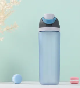 Detail shot of frosted plastic sports water bottle with blue lid and aesthetic green background.