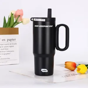 Detail view of black stainless steel insulated tumbler with straw and handle for cold drinks.