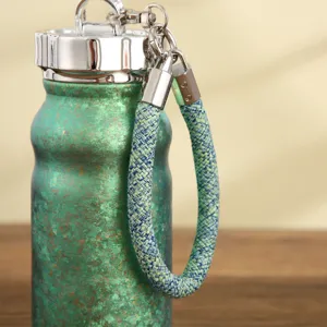 Mini borraccia termica con cordino intrecciato, finitura verde metallizzata per dai colori.