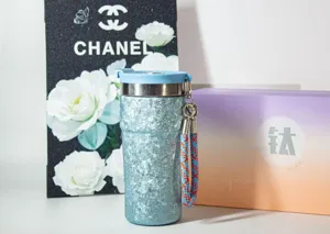 Gobelet en pur titane tasse de voyage avec couvercle magnetique et laniere tressée detail.