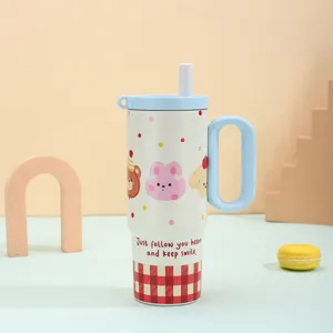 Stainless steel vacuum insulated tumbler with handle and straw lid, cute cartoon design details.
