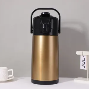 Detailed view of large thermal airpot with golden brushed finish and black top handle.