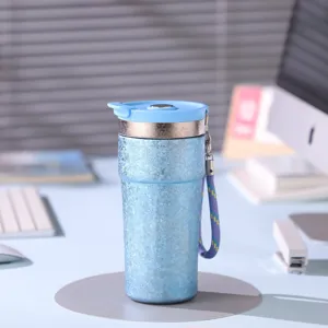 Gros plan sur la tasse isolante en titane bleu portable avec lanière pratique pour un usage quotidien.