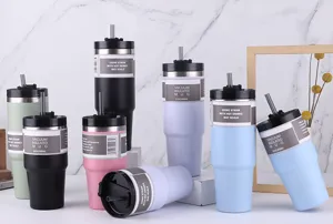 Vue détaillée de tasses de voyage isothermes en acier inoxydable multicolores avec paille.