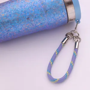 Détail en gros plan d'une tasse thermos en titane moucheté bleu avec cordon tressé.