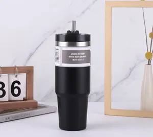 Gros plan détaillé d'un gobelet isotherme en acier inoxydable noir avec paille et finition.
