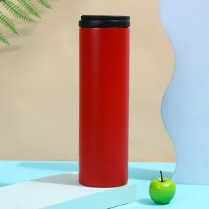 Detail view of a modern red stainless steel vacuum insulated coffee travel mug on a blue podium.