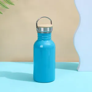Detail shot of blue stainless steel water bottle with wooden lid and handle in studio setting.